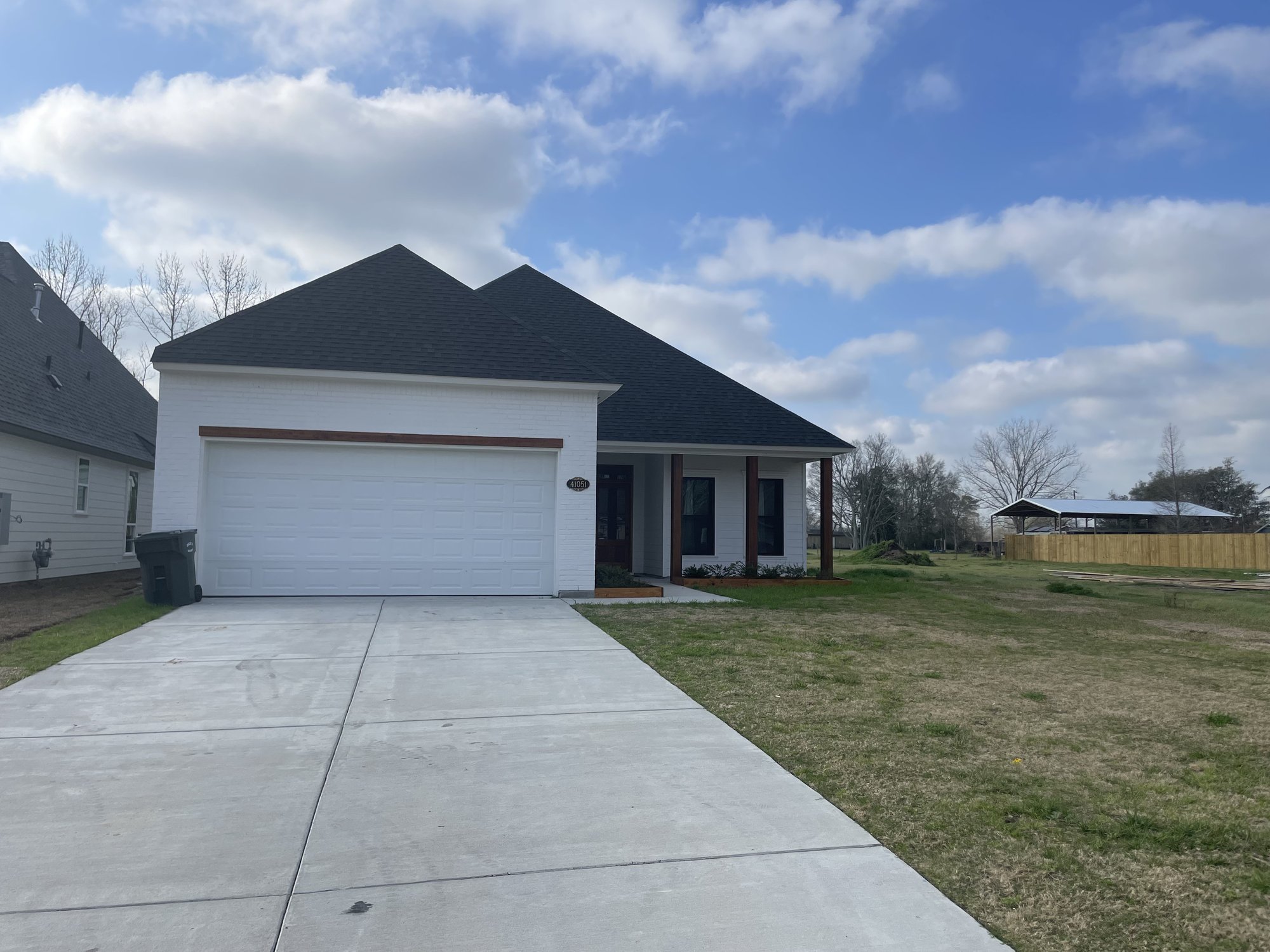 White brick new-construction home with two-car garage